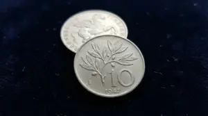 Moneta italiana da 10 lire del 1947 fotografata in primo piano su sfondo scuro