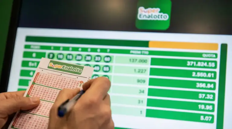 Mani che compilano una schedina del SuperEnalotto davanti a uno schermo con risultati e importi della vincita